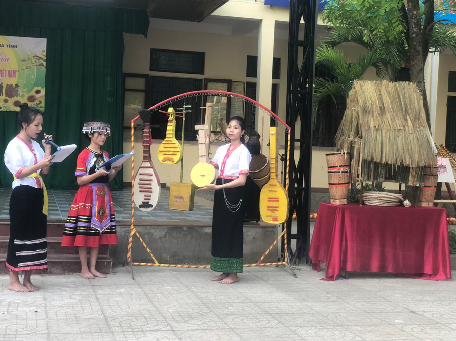 Các em học sinh giới thiệu về nhạc cụ và các vật dụng dân tộc. (Ảnh: Bá Hải).