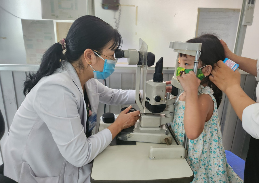 Bác sĩ Trần Thị Thúy Ngân khám mắt cho trẻ. Bác sĩ Trần Thị Thúy Ngân khám mắt cho trẻ.