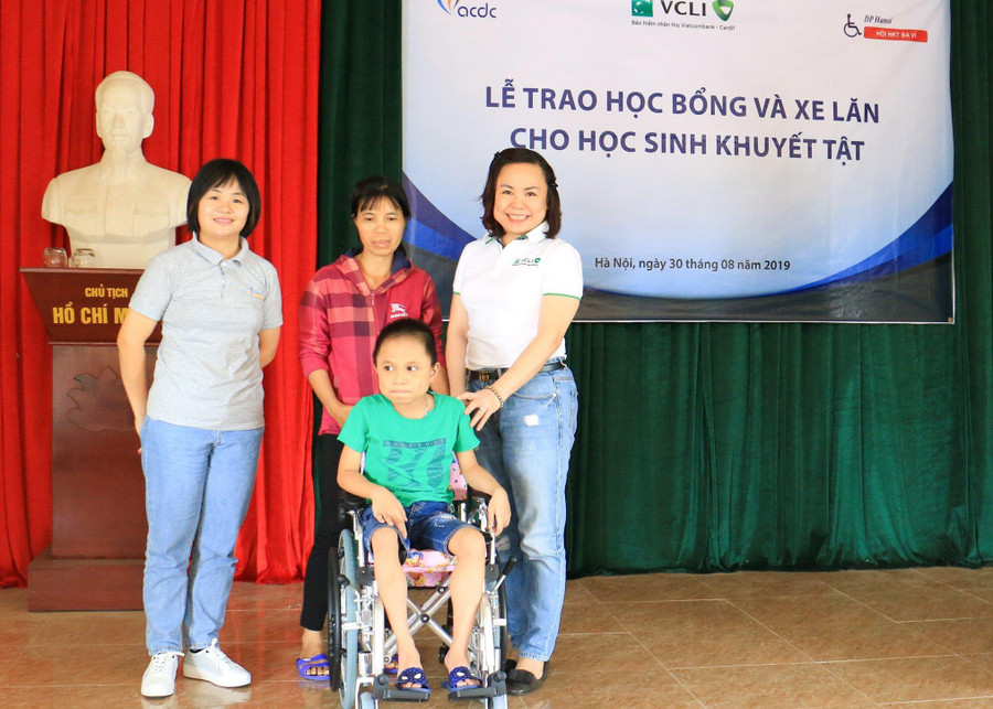 Đại diện Trung tâm ACDC và VCLI lên trao xe lăn cho học sinh khuyết tật