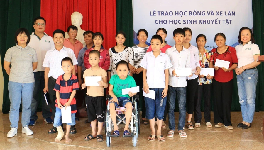 Đại diện Trung tâm ACDC và VCLI lên trao học bổng và xe lăn cho học sinh khuyết tật