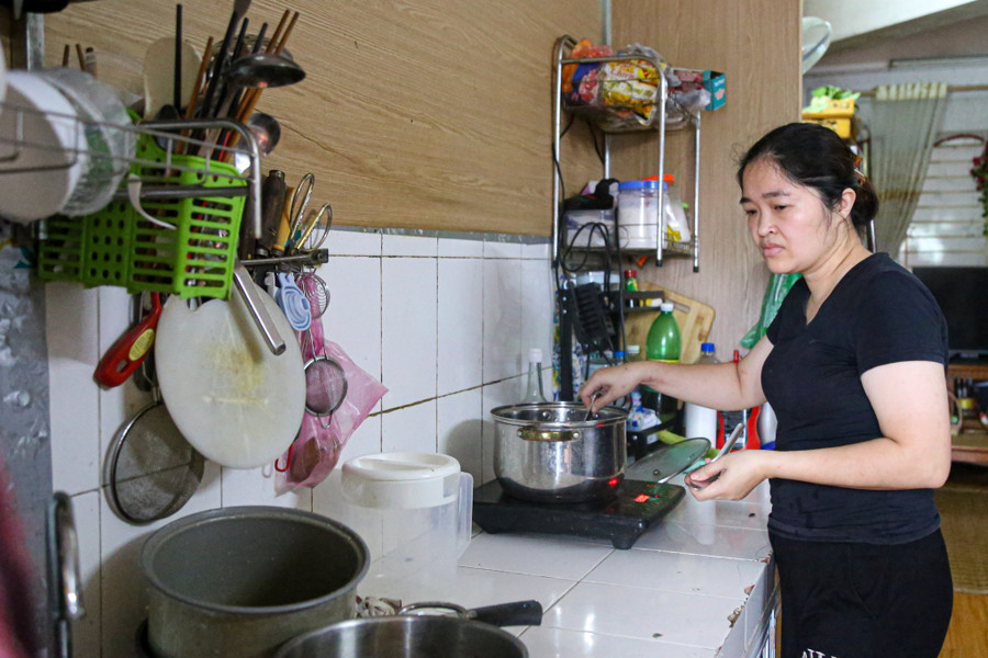 Một nữ công nhân ở Hà Nội tranh thủ tan ca về sớm nấu cơm cho gia đình.