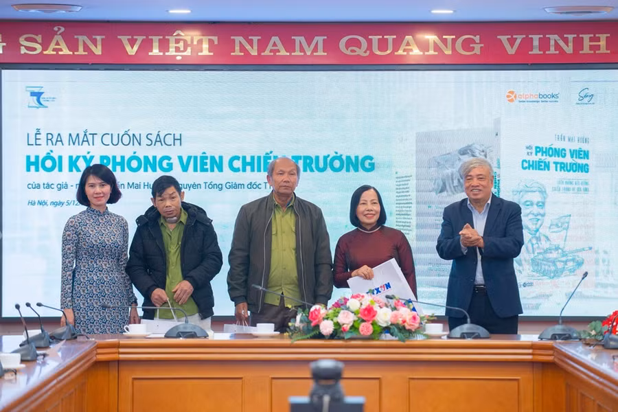 Nhà báo Trần Mai Hưởng (bìa phải) tặng sách cho các nhân chứng lịch sử. Ảnh: Thảo Quyên.