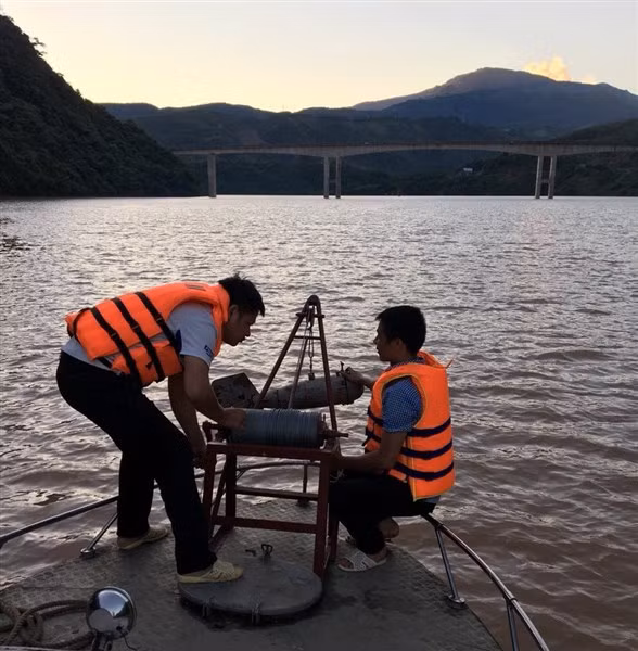 Các cán bộ, quan trắc viên của Trạm Thủy văn Mường Lay thả “cá sắt” (máy đo lưu lượng nước) xuống sông để thực hiện quan trắc.