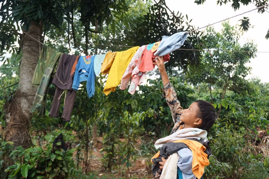 A Khả cất vội quần áo, tránh cơn mưa chiều.