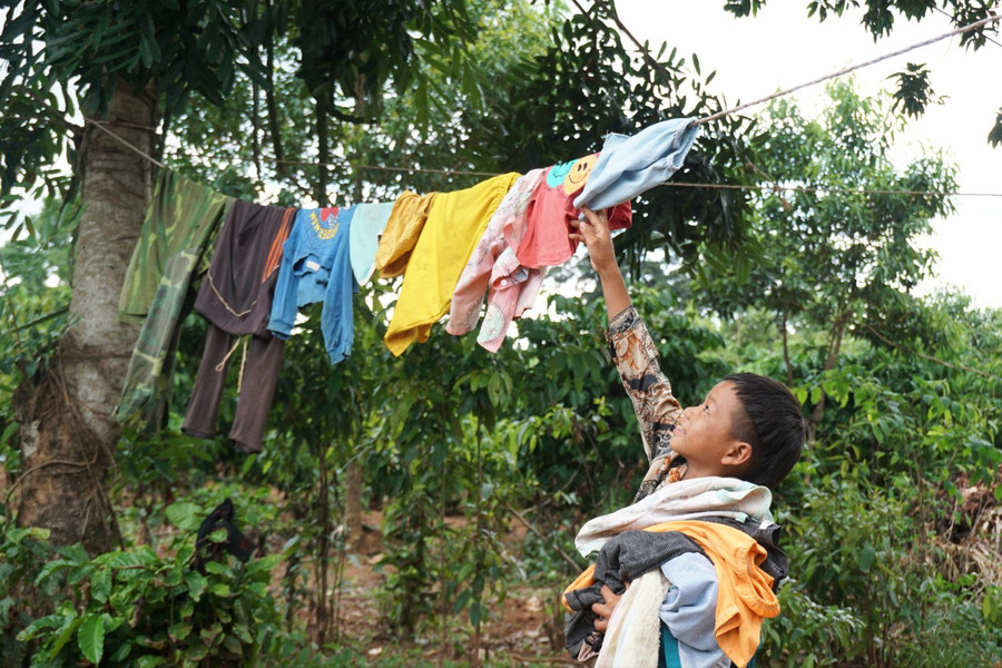 A Khả cất vội quần áo, tránh cơn mưa chiều.