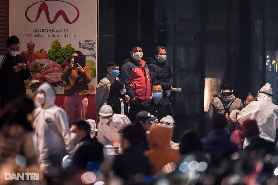 Để đảm bảo quy trình lấy mẫu xét nghiệm được thuận lợi, mọi người tới lấy mẫu sẽ nhận tờ khai, ngồi lần lượt theo các hàng ghế được sắp xếp cố định trong sân khu tập thể và lần lượt thực hiện các bước theo hướng dẫn của nhân viên y tế. Ảnh: Dân trí.