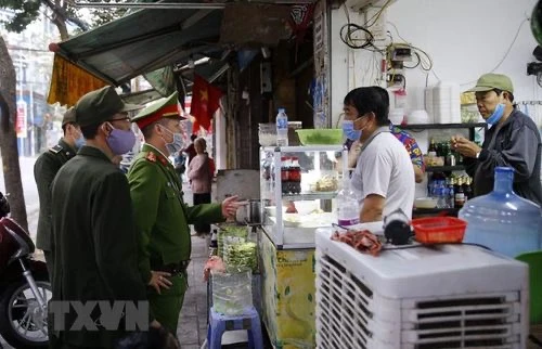 Lực lượng chức năng Công an phường Hàng Mã ra quân đề nghị các hộ kinh doanh đóng cửa quán ăn đường phố, trà đá, càphê. (Ảnh: Doãn Tấn/TTXVN).