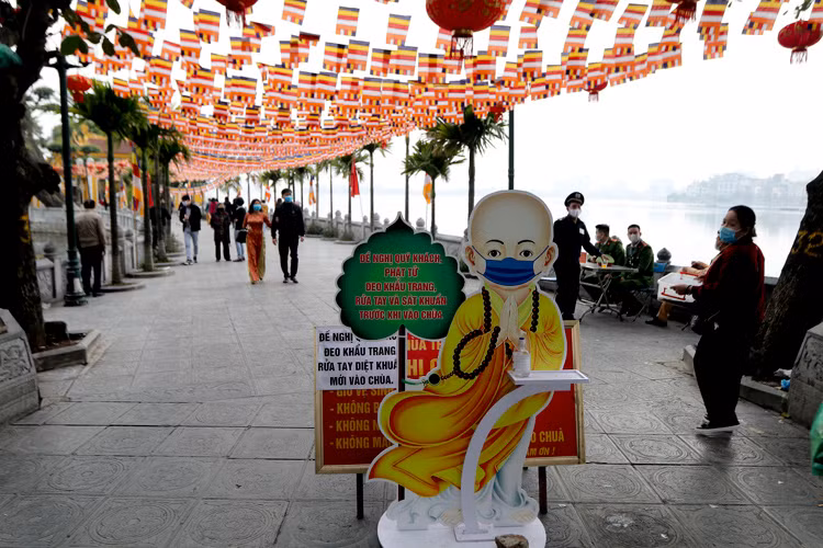 Tại chùa Trấn Quốc, công tác phòng chống dịch được chuẩn bị chu đáo như nước rửa tay cho người dân, đồng thời nhắc nhở người dân đeo khẩu trang trong suốt quá trình đi lễ. Ảnh: Baotintuc.