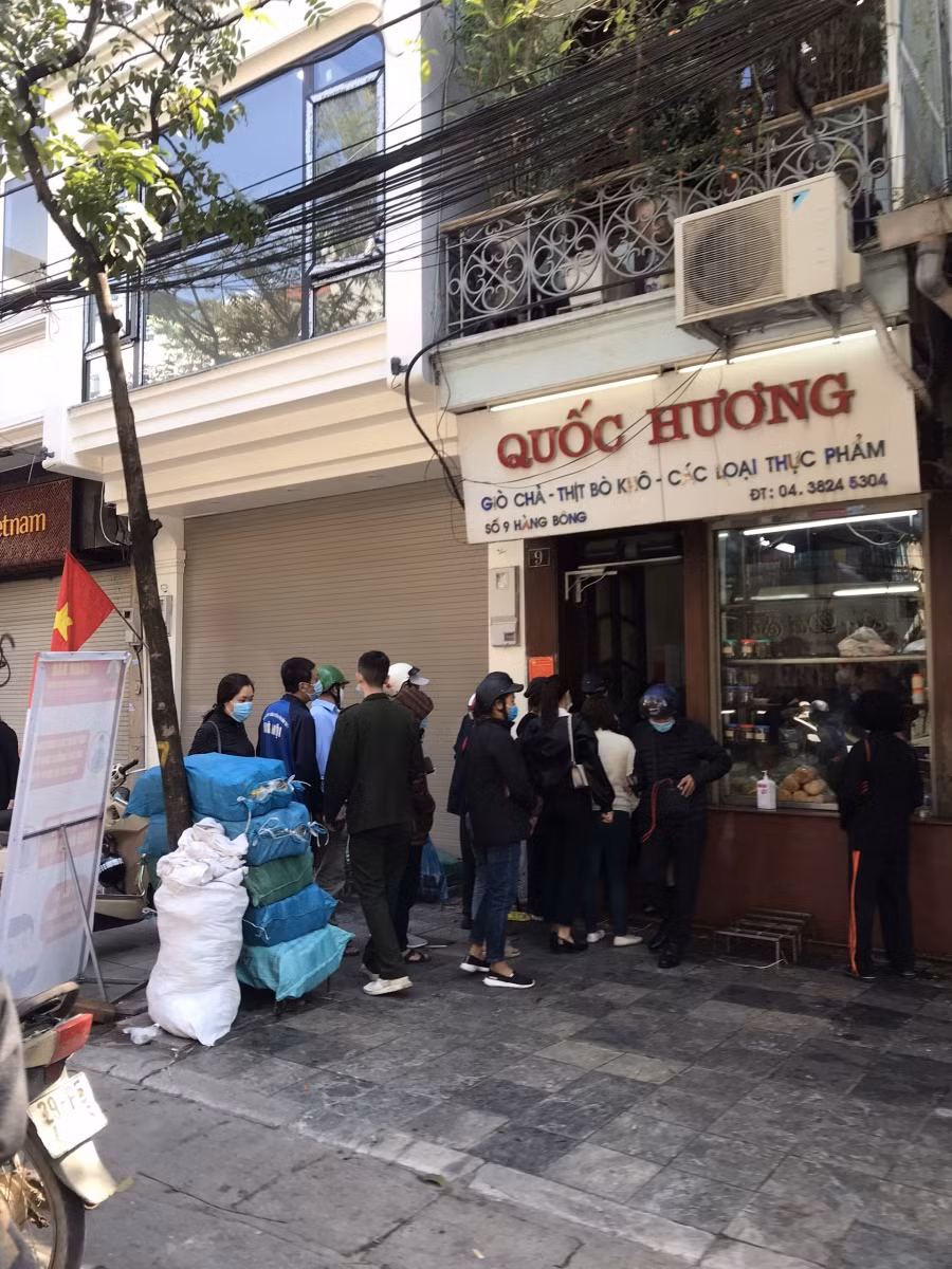 Một số người dân xếp hàng mua giò chả tại một cửa hàng nổi tiếng trên phố Hàng Bông để dùng cho dịp Tết Nguyên đán.