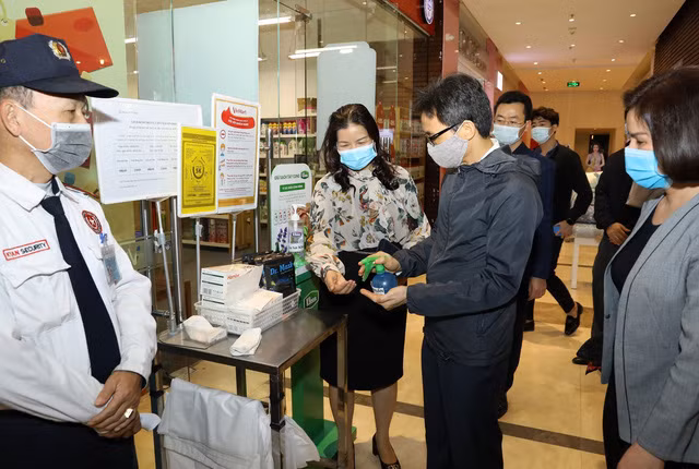 Phó Thủ tướng Vũ Đức Đam đo thân nhiệt, sát khuẩn tay tại Trung tâm Thương mại Syrena (Tây Hồ, Hà Nội). Ảnh: VGP