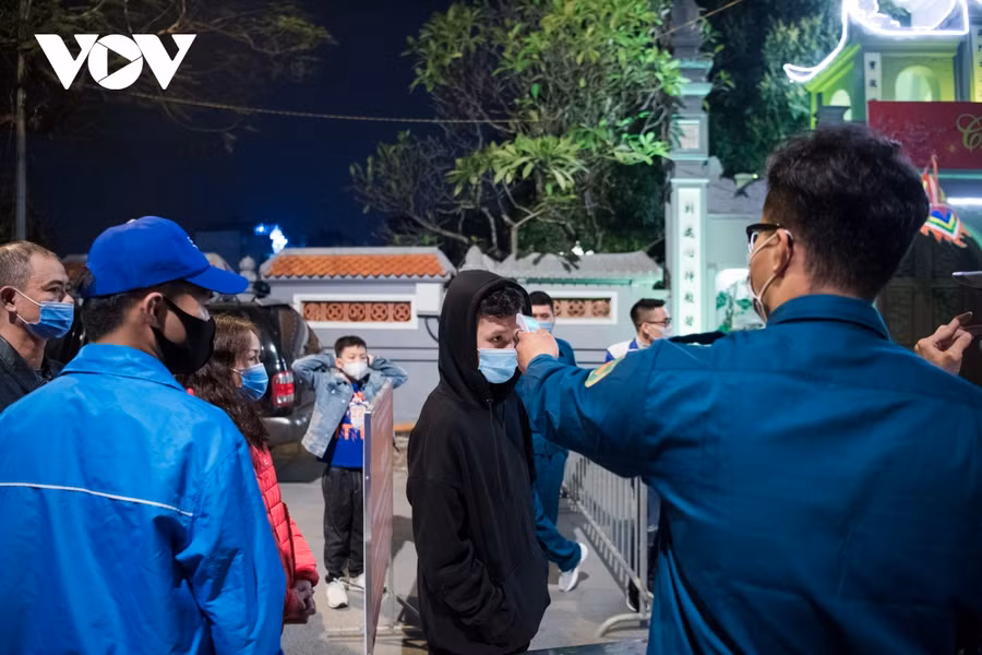 Người dân trước khi vào chùa Hà được kiểm tra thân nhiệt. Để đảm bảo công tác phòng tránh dịch bệnh Covid-19 nên chùa chỉ cho khoảng 30 người vào một lượt. Ảnh: VOV.