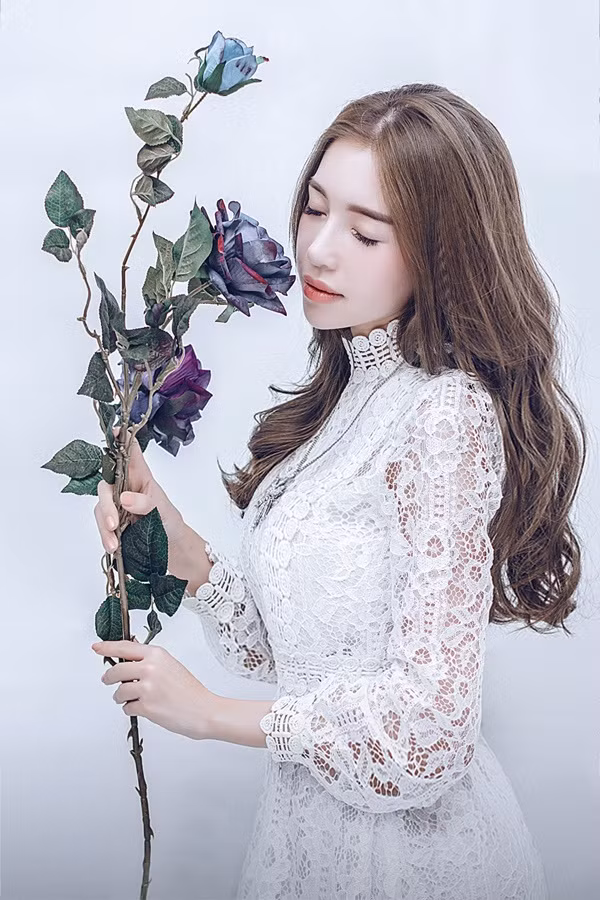 Bà mẹ hai con tự trang điểm cho bản thân theo phong cách Hàn Quốc. Bộ ảnh được thực hiện với style tối giản, khi Elly Trần diện những chiếc váy có sắc trắng đơn giản và tạo dáng bên hoa lãng mạn.