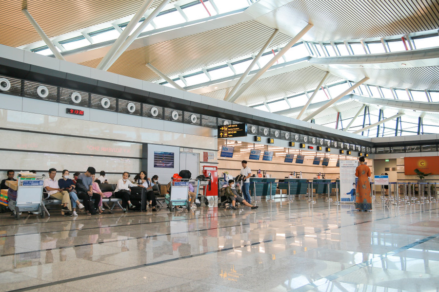 Các hành khách ngồi chờ làm thủ tục lên máy bay tại Nhà ga T2.