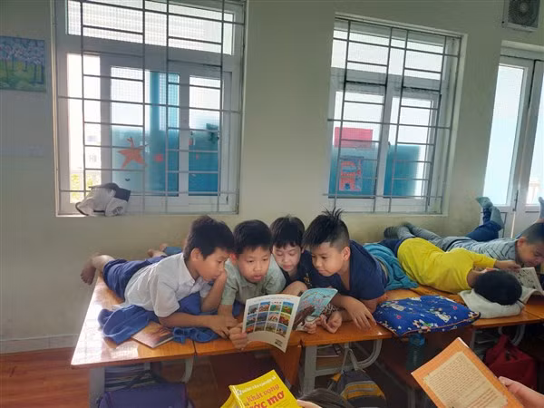 Các cô cậu học trò lớp 5A3 Trường Tiểu học Thanh Xuân Trung, quận Thanh Xuân, Hà Nội đọc sách trước giờ ngủ trưa. Ảnh: NH