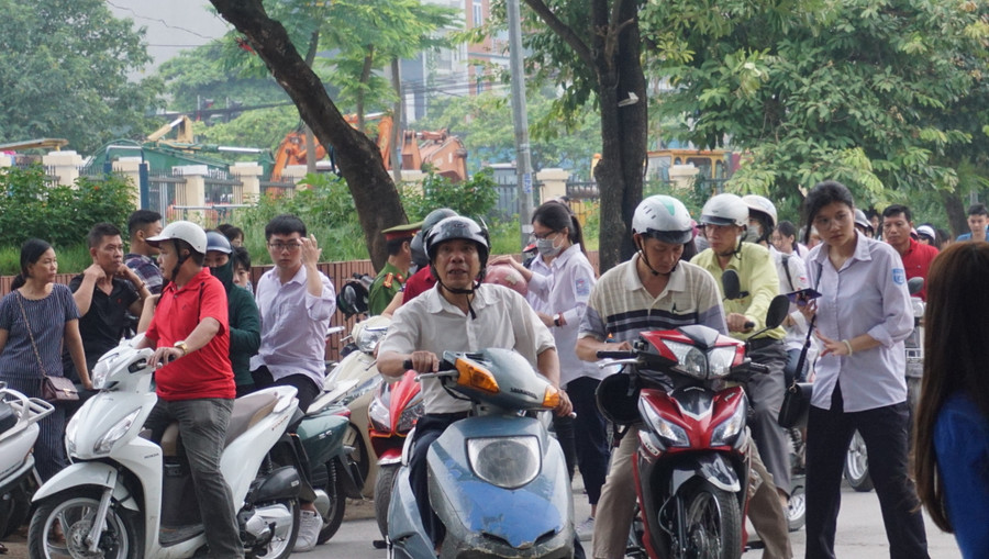 Khá đông phụ huynh đưa con đến trường thi vẫn nán lại chờ con vào thi mới về