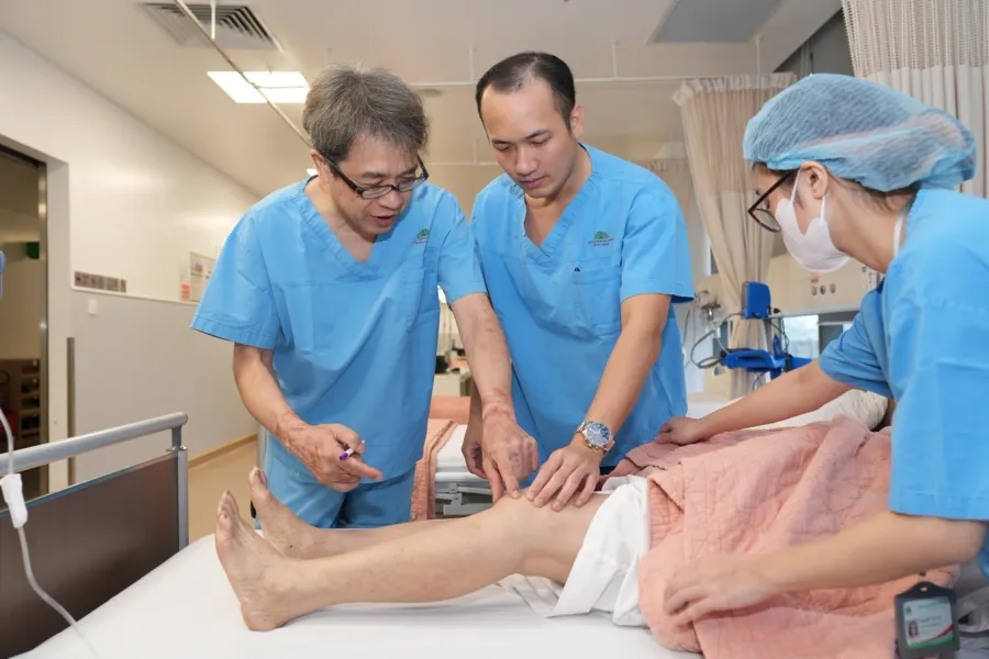 TS.BS. Lê Quang Huy (giữa) và GS. Hiranaka Takafumi (bìa trái) thăm khám bệnh nhân trước phẫu thuật.
