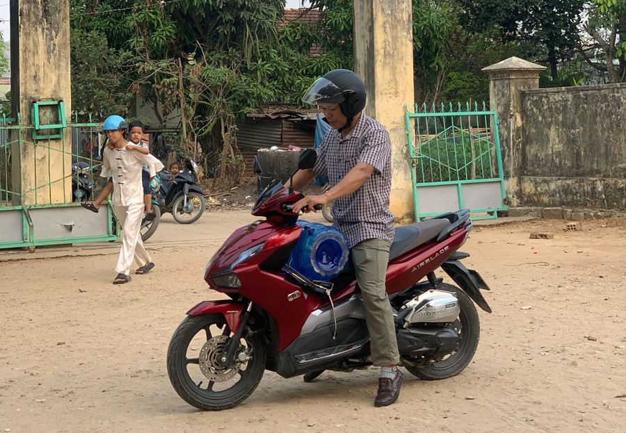 Giáo viên điểm trường làng Rắc, Trường Tiểu học - THCS xã Ya Xiêr tranh thủ chở từng bình nước về cho học sinh sử dụng. Ảnh: Dung Nguyễn.