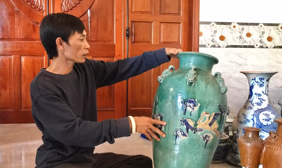 Ông Lê Tấn Khoang nâng niu bộ sưu tập cổ vật của mình.
