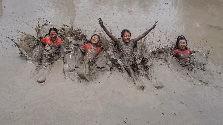Trẻ em bị bùn cuốn hút như nam châm trước sắt. Ảnh: Getty Images.
