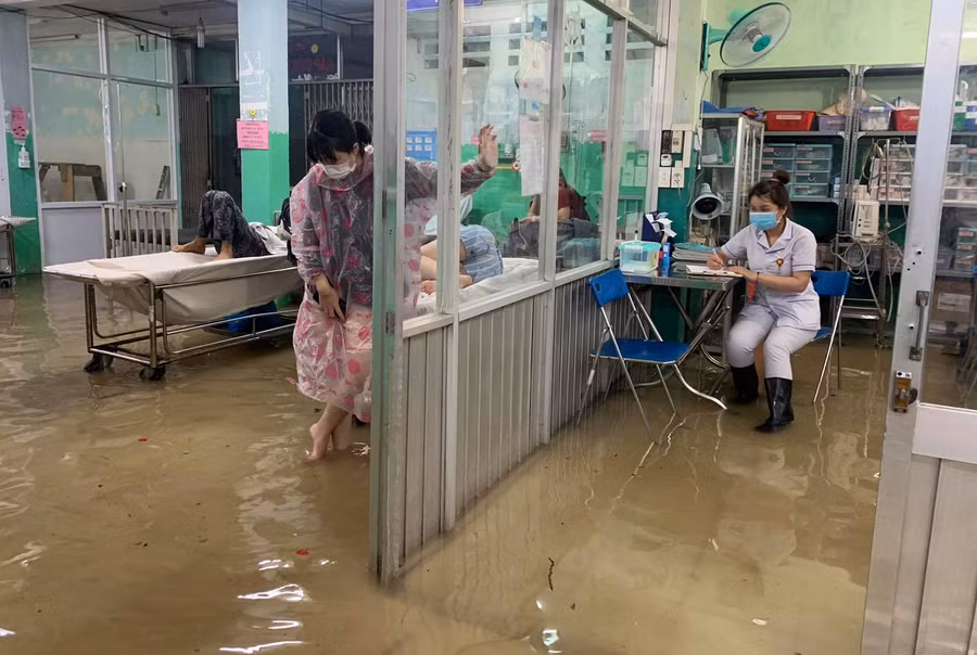 Nước ngập như sông, người dân đến khám làm thủ tục phải lội bì bõm trong nước. Ảnh: Đông Thịnh