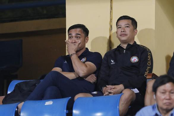 Huấn luyện viên Đức Thắng (trái) ngồi trên khán đài do phải nhận thẻ đỏ vì lỗi phản ứng với trọng tài ở vòng đấu trước. Huấn luyện viên Đức Thắng (trái) ngồi trên khán đài do phải nhận thẻ đỏ vì lỗi phản ứng với trọng tài ở vòng đấu trước.