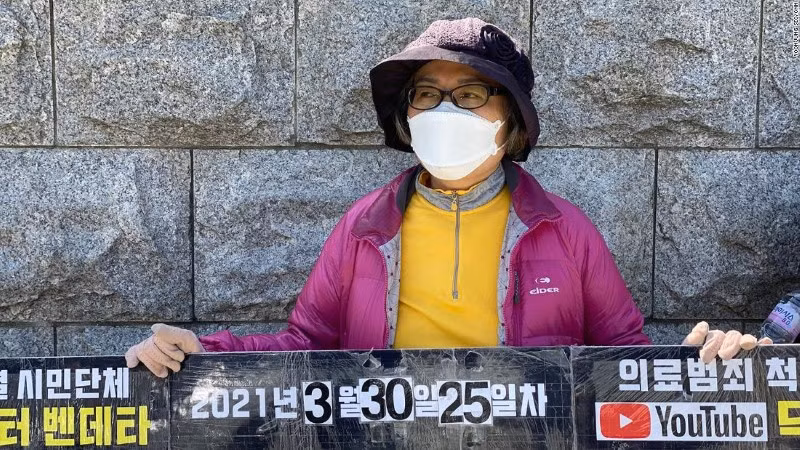 Bà Lee Na Geum ôm biểu ngữ, biểu tình trước tòa Quốc hội Hàn Quốc.