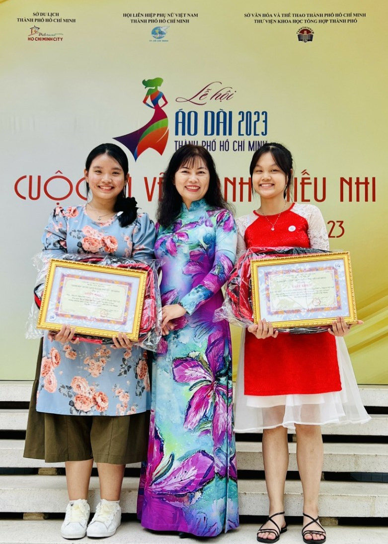 Cô Trần Đoàn Thanh Ngọc cùng em Trần Thanh Trúc và em Hoàng Nguyễn Phương Nhi trong buổi trao giải cuộc thi vẽ tranh thiếu nhi Áo dài và hoa năm 2013.