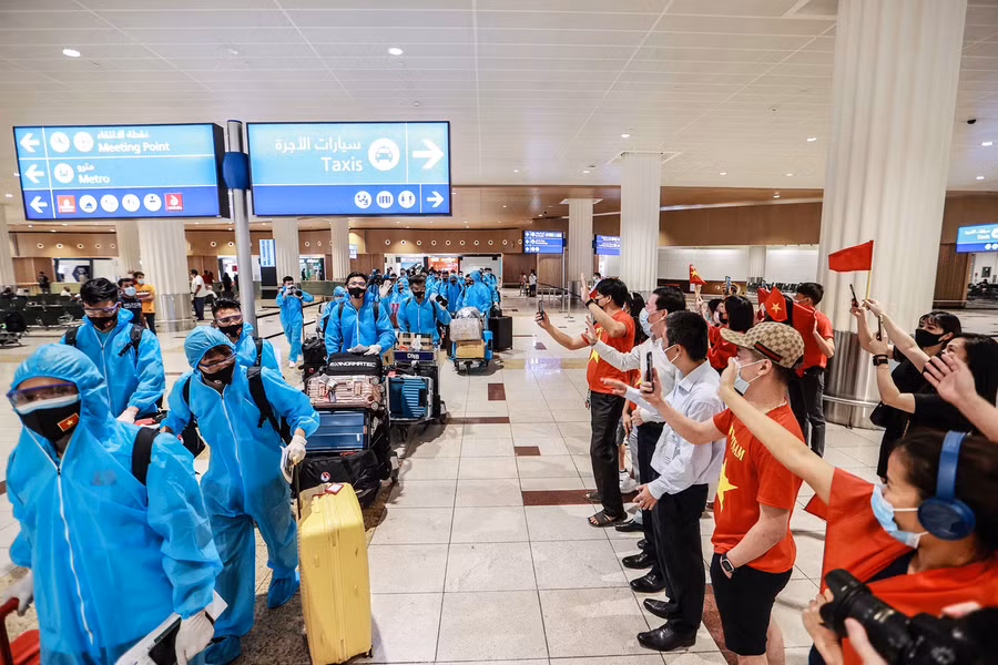 Đội xuống sân bay với áo bảo hộ và có khá đông người Việt tại UAE chào đón.