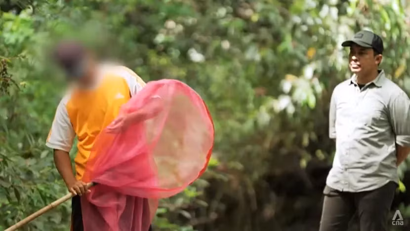 Nhà làm phim tài liệu Arfan Sabran (phải) với thợ săn các loài bướm Joyo. Ảnh: CNA