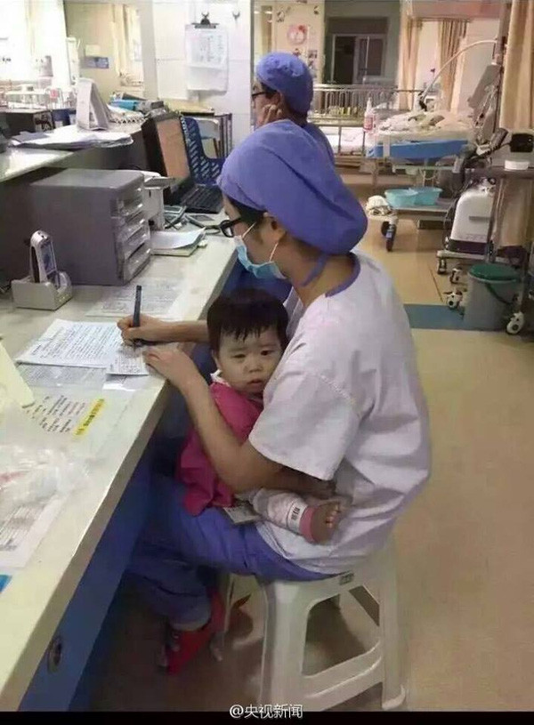 Nữ y tá vừa bế trẻ mồ côi vừa làm việc gây xúc động mạnh