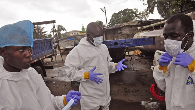 Nhân viên y tế Liberia chuẩn bị các dụng cụ trước khi đưa xác một bệnh nhân Ebola ra khỏi nhà tại thủ đô Monrovia hôm 29/8. Ảnh: AP Nhân viên y tế Liberia