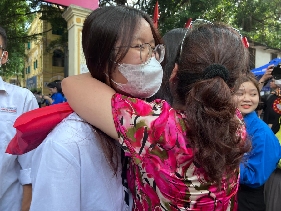 Mẹ ôm chặt con gái chia sẻ niềm vui khi biết con thi tốt môn Toán.