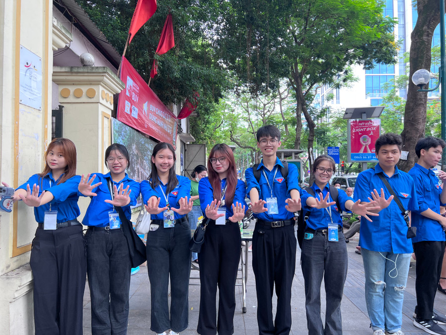 Tình nguyện viên xếp hàng dài chào đón thí sinh ngay từ cổng trường.