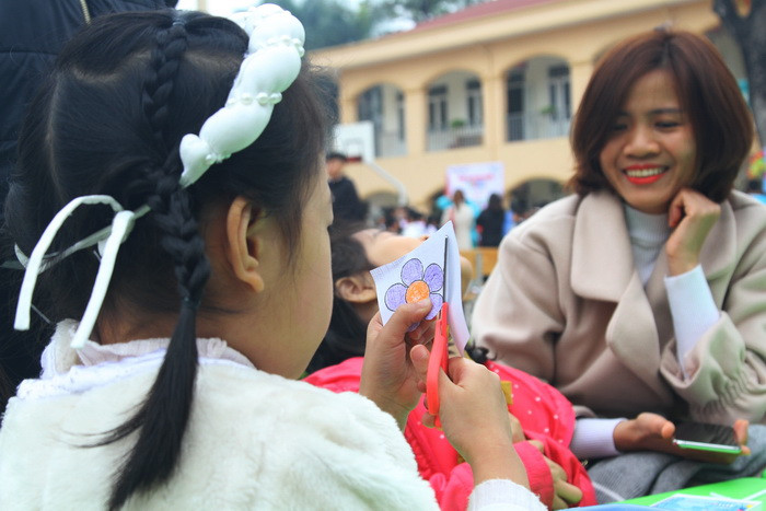 Trẻ này đang thực hiện cắt, dán hoa giấy.