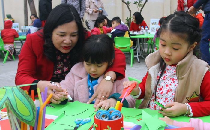 Cô Trần Thị Kim Thu đang hướng dẫn trẻ cách thực hiện một sản phẩm bươm bướm bằng giấy.