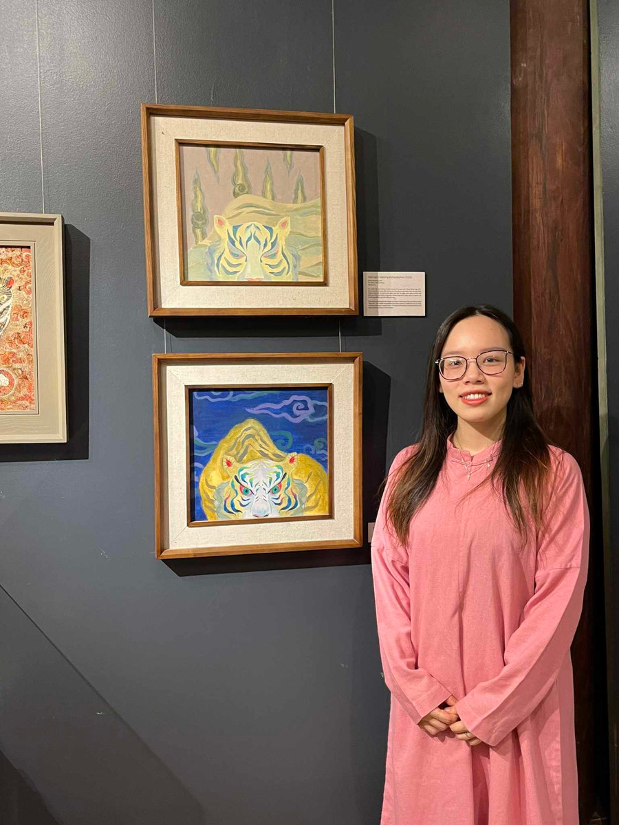 Họa sĩ Đặng Phương Linh bên tác phẩm của mình tại triển lãm. Ảnh: NVCC.