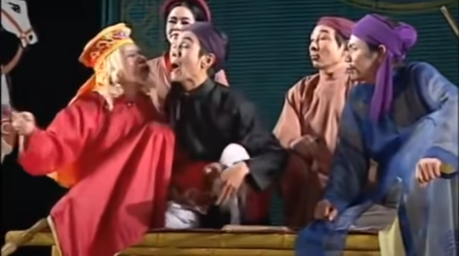 GS.NSND Trần Bảng là người khai thác, xếp trò và đưa các tích chèo cổ lên sân khấu chèo hiện đại. (Trong ảnh: Lớp diễn &apos;Việc làng&apos; trong vở chèo cổ &apos;Quan Âm Thị Kính&apos; của Nhà hát Chèo Việt Nam). Ảnh chụp màn hình.