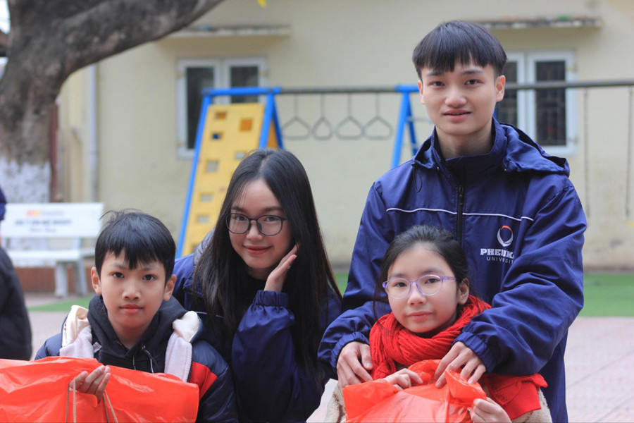 Phó Trưởng BTC Trần Hữu Nam (bên phải) cùng nhà tài trợ gạo Nguyễn Thị Minh Phương trao quà cho các em nhỏ.