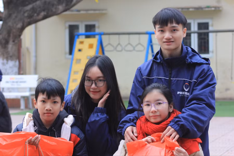 Phó Trưởng BTC Trần Hữu Nam (bên phải) cùng nhà tài trợ gạo Nguyễn Thị Minh Phương trao quà cho các em nhỏ.