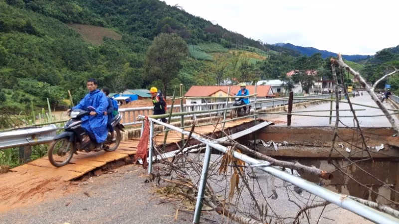 Cây cầu bắc qua sông Pô Kô bị “đứt” một đoạn, người dân phải bắc cầu tạm bằng ván để di chuyển qua lại.