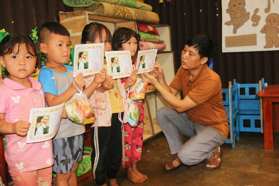 Thầy Hải trao chứng nhận cháu ngoan Bác Hồ cho học sinh.