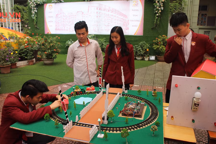 Nhóm học sinh THPT và mô hình ý tưởng "Rào chắn barie tự động an toàn đường sắt”. Ảnh: Thạch Thảo.
