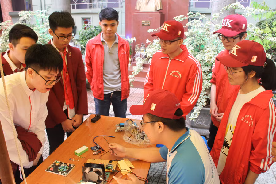 Nhóm sinh viên Đại học Bách Khoa Hà Nội giúp học sinh Trường Nguyễn Bỉnh Khiêm tìm hiểu sản phẩm sáng tạo trong Ngày hội "Tuổi trẻ sáng tạo". Ảnh: Thạch Thảo.