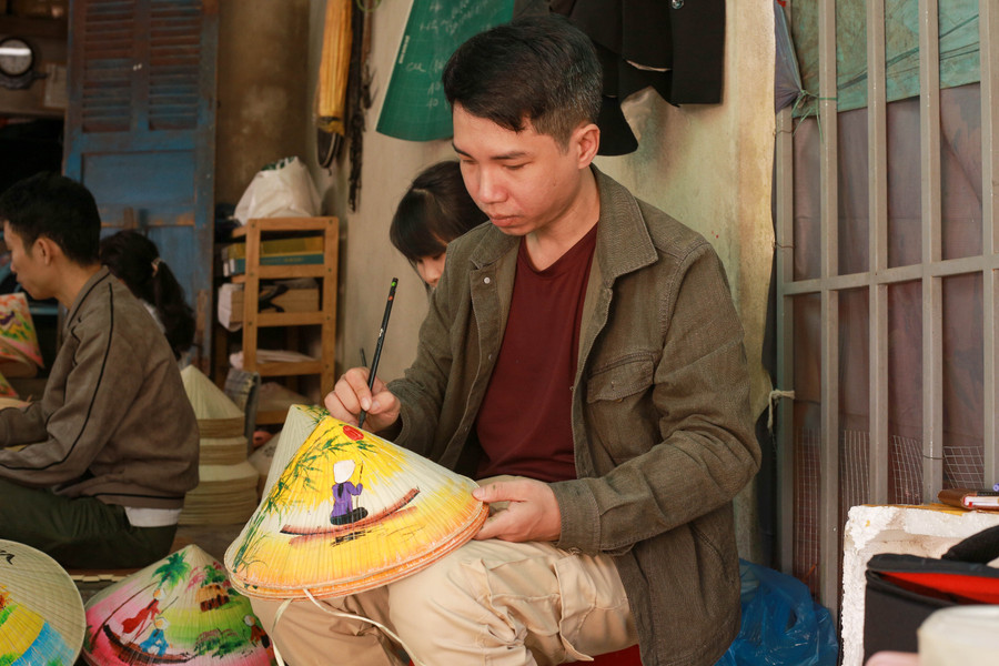 Chàng trai 9x Nguyễn Gia Hùng đang vẽ những bức tranh vẽ trên nón lá. Chàng trai 9x Nguyễn Gia Hùng đang vẽ những bức tranh vẽ trên nón lá.