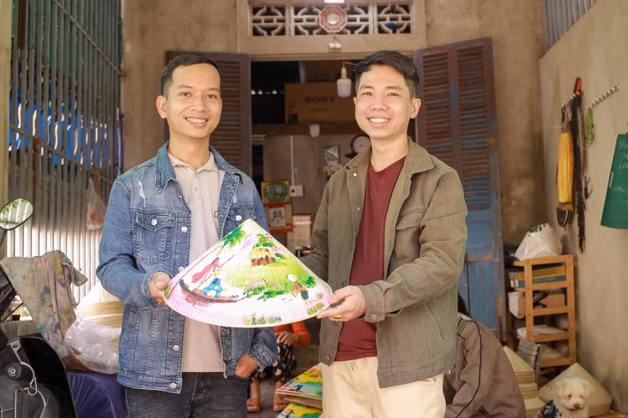 Tư vấn các loại tranh trên nón và chụp hình lưu niệm với khách.