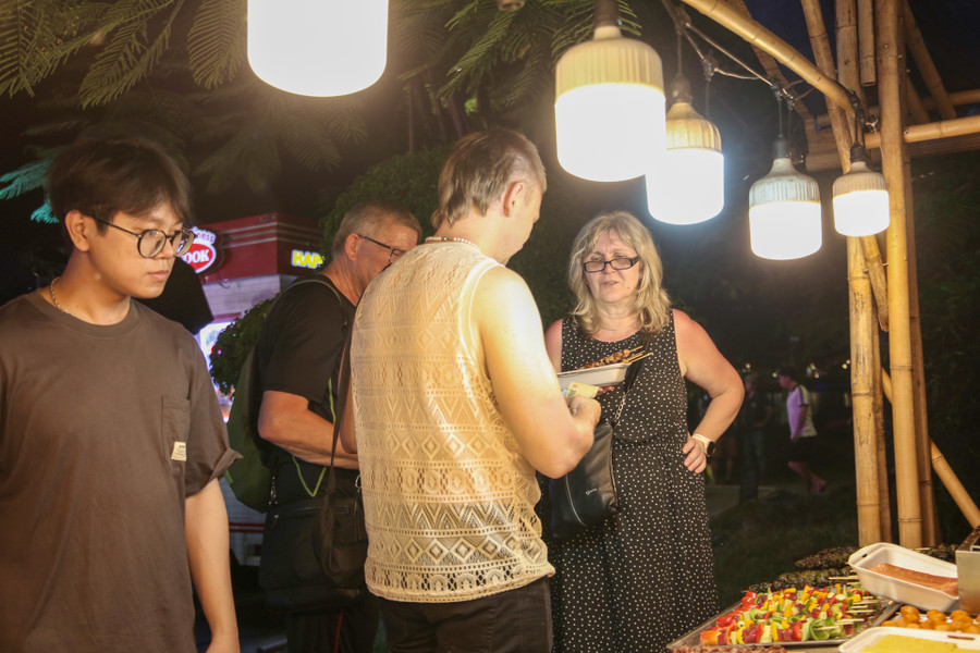 Nhiều du khách nước ngoài thích thú với các món ăn tại gian hàng ẩm thực.