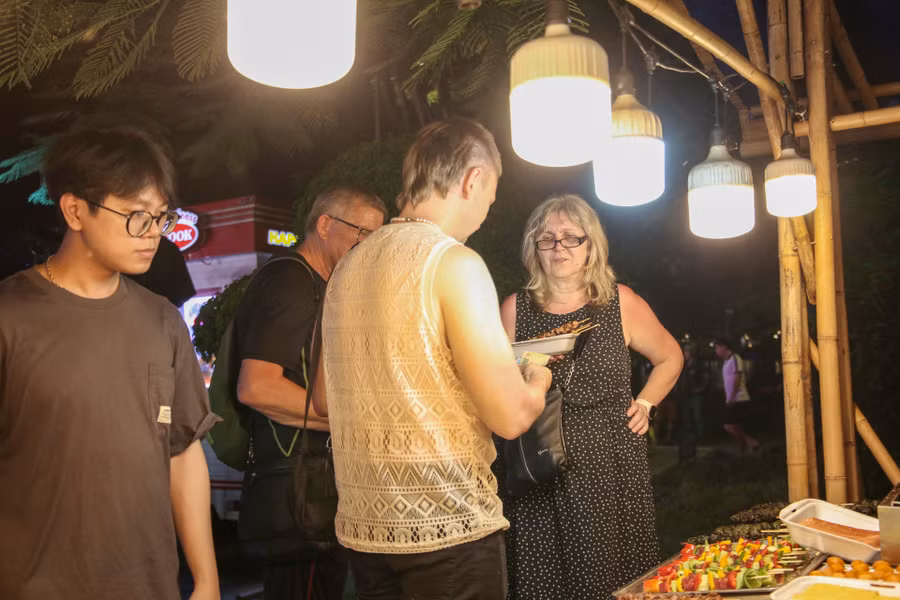 Nhiều du khách nước ngoài thích thú với các món ăn tại gian hàng ẩm thực.