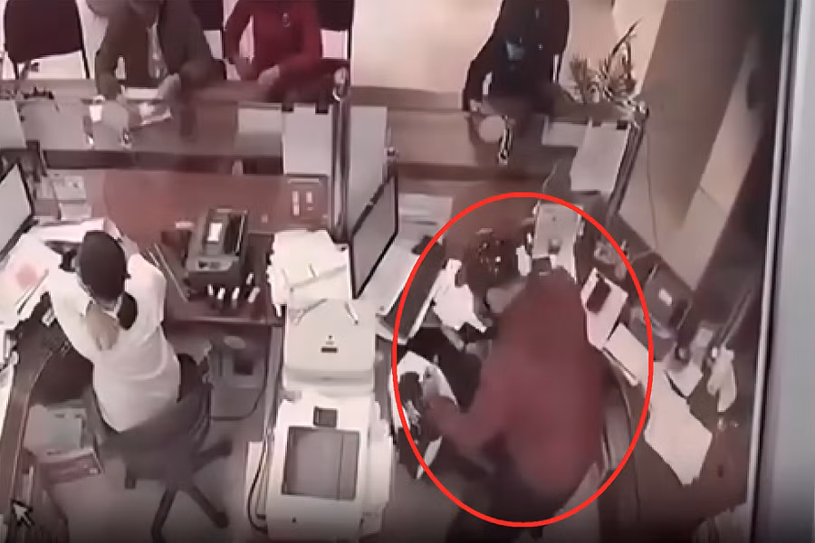 Nghi phạm dùng dao khống chế nhân viên ngân hàng. Ảnh cắt từ video