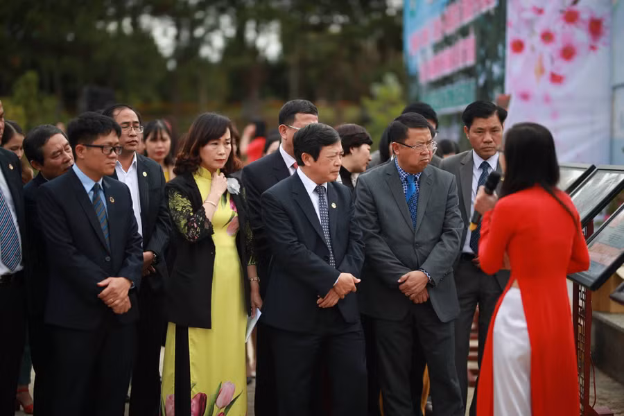 Khách mời nghe giới thiệu về những bức tranh trưng bày tại triển lãm