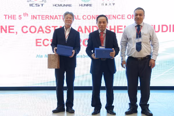 PGS.TS Vũ Xuân Cường tặng quà lưu niệm cho hai đối tác tham dự Hội nghị.